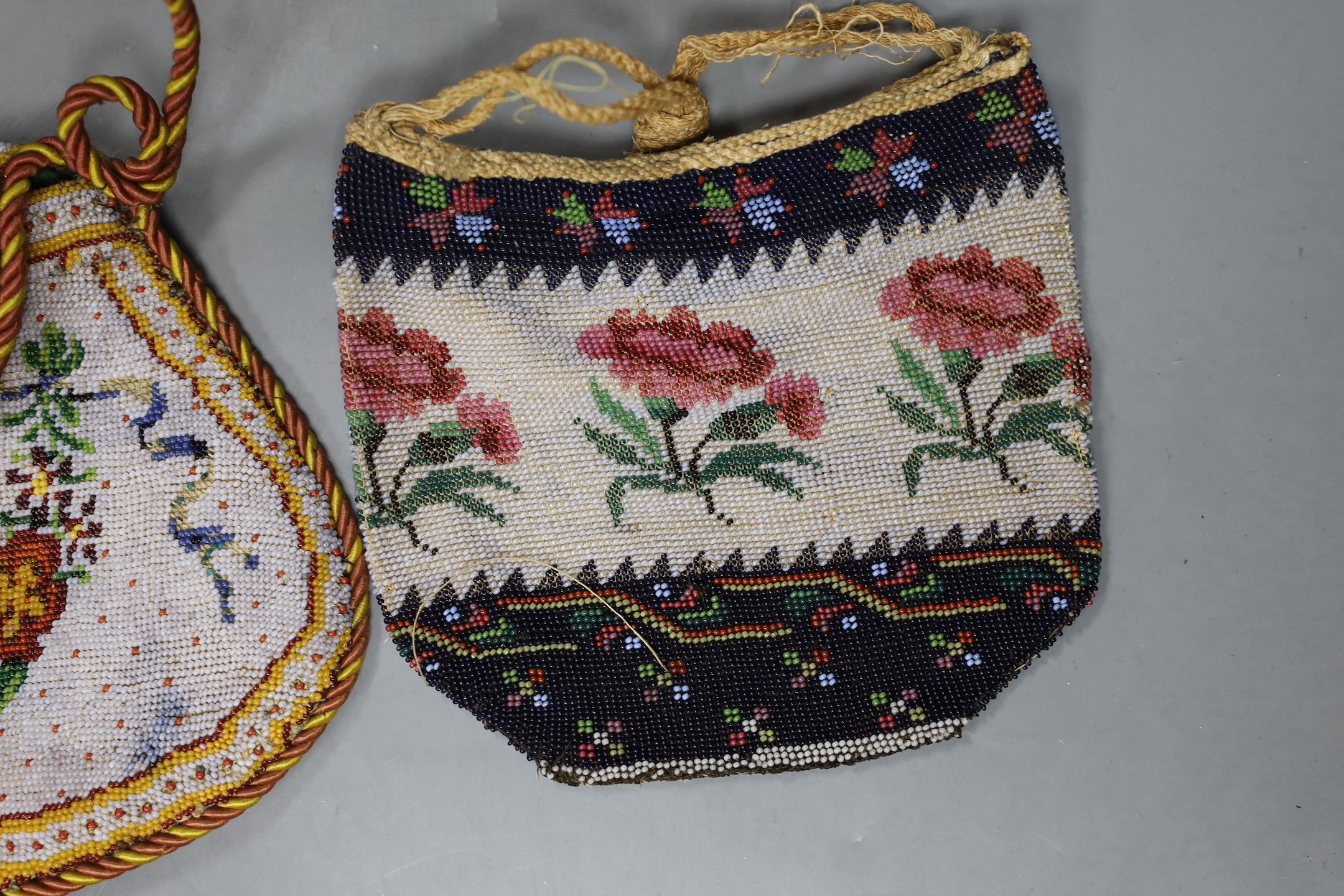 A 19th century shaped floral bead worked bag with corded edging and handle, an unusual bead worked misers purse and two small floral bead bags